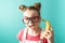 Modern technology: A teenager girl in funny glasses uses a yellow banana as a phone.