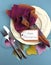 Modern Thanksgiving dining table place setting with autumn leaves - vertical