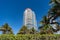 Modern towerblocks bottom view on blue sky with palms and hedge in South Beach, USA