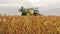 Modern tractor with agricultural machinery on golden field