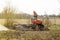 Modern tractor machinery plowing agricultural field meadow at farm at spring autumn. Farmer cultivating and make soil