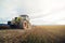 Modern tractor working on the farm, a modern agricultural transport, cultivation of fertile land, tractor on cloudy sky background