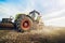 Modern tractor working on the farm, a modern agricultural transport, cultivation of fertile land, tractor on cloudy sky background