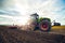 Modern tractor working on the farm, a modern agricultural transport, cultivation of fertile land, tractor on cloudy sky background