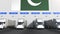 Modern trailer trucks load or unload at warehouse bays with flag of Pakistan. Pakistani logistics related conceptual 3D