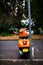 Modern urban orange Motor Scooter parking at the side of the road background