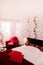 Modern vibrant colourful bedroom interior with red armchair, pillow and graphic pattern wallpaper