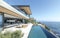 Modern villa with an infinity pool overlooking the ocean, featuring expansive outdoor living space.