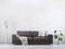 Modern vintage living room. Brown leather sofa on a grey wooden floor and light wall, 3D render