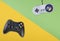 Modern and vintage videogame controller over green and yellow background