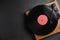 Modern vinyl record player with disc on black background, top view. Space for text