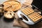 Modern waffle maker with ingredients on grey table