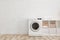 Modern washing machine near brick wall in laundry room interior