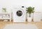 Modern washing machine, towels and related objects in laundry room