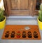 Modern Welcome zute doormat with small black plants and watering colorful plant outside home with yellow flowers and leaves