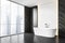 Modern white bath in a big bathroom with backlight, tile black wall on the side