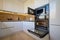 Modern white and beige wooden kitchen interior with oven opened