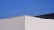 Modern white and black Aluminium Corrugated Factory Buildings with steel Fence on Rooftop against blue clear sky background