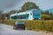 Modern white and blue commuter train, brand new addition to the slovenian rails on a ride towards Ljubljana. Commuting with a