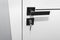 Modern white door with matte black handle and magnetic locks, lock with key inserted.