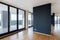 Modern white empty loft apartment interior with parquet floor with black column and panoramic windows, Overlooking the metropolis