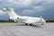 Modern white executive aircraft on the airport apron on a cloudy day