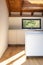 Modern white kitchen detail with steel sink, small island and window overlooking nature. Natural light