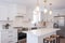 Modern white kitchen interior with an oven, sink, faucet, a wooden cabinet, and table