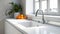 Modern white minimalistic kitchen interior details. Stylish white quartz countertop with kitchen sink with water tap