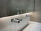 Modern white sink with big mirror and contemporary metal faucet