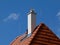 Modern white stucco finished chimney and bright brown red clay tile roof