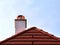 Modern white stucco finished chimney and bright brown red clay tile roof