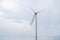 Modern wind turbine renewable energy during daylight with cloudy sky, view from low angle