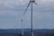 Modern wind turbines in a hazy landscape