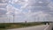 Modern windmills along the road against the blue sky