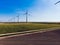 Modern windmills on rural landscape area under blue sky