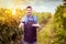 Modern winemaker in vineyard holding glass of red wine and variety of italian food