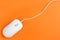 Modern wired optical mouse on orange background