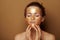 Modern woman with golden mask making facial self massage