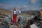 Modern woman on landfill, consumerism versus pollution concept.