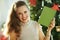 Modern woman near Christmas tree showing notebook