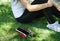 Modern woman, wireless headphones and smartphone on the grass