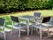 Modern wooden dining table set in the green garden