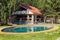 Modern wooden house with tiled roof, swimming pool and patio area. Solid log cottage for a comfortable stay and living outside the
