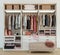 Modern wooden wardrobe with clothes hanging on rail in walk in closet design interior