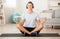 Modern workout with music at home. Smiling guy in headphones enjoys yoga and meditation