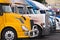 Modern yellow semi truck on foreground of other trucks