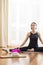 Modern Yoga Lifestyle Concepts. Relaxed and Tranquil Caucasian Woman in Yoga Pose Indoors. Posing In Front of Big Window With