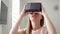 Modern young pretty woman using VR virtual reality 360 glasses at home. Future is female concept