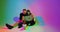 Modern young teen girl and boy with laptop watching movies, series, playing or shopping online. Colorful neon light